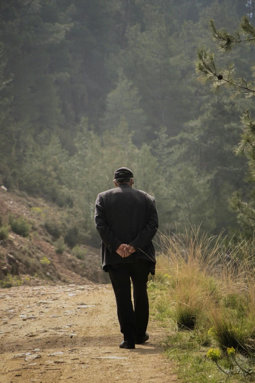 man walking away down a path in the woods