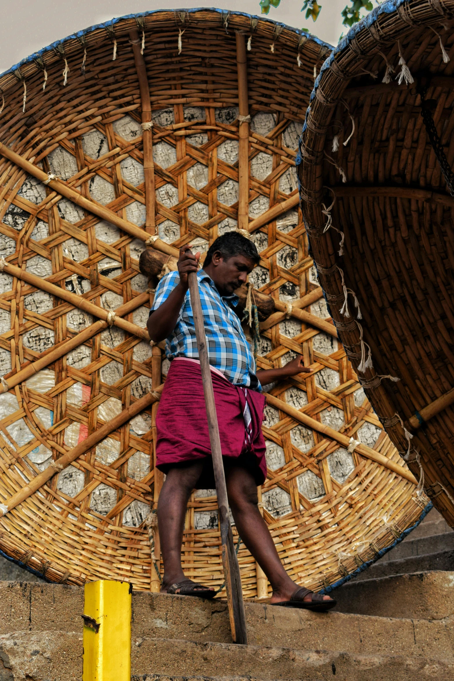 a man sitting in front of a woven object