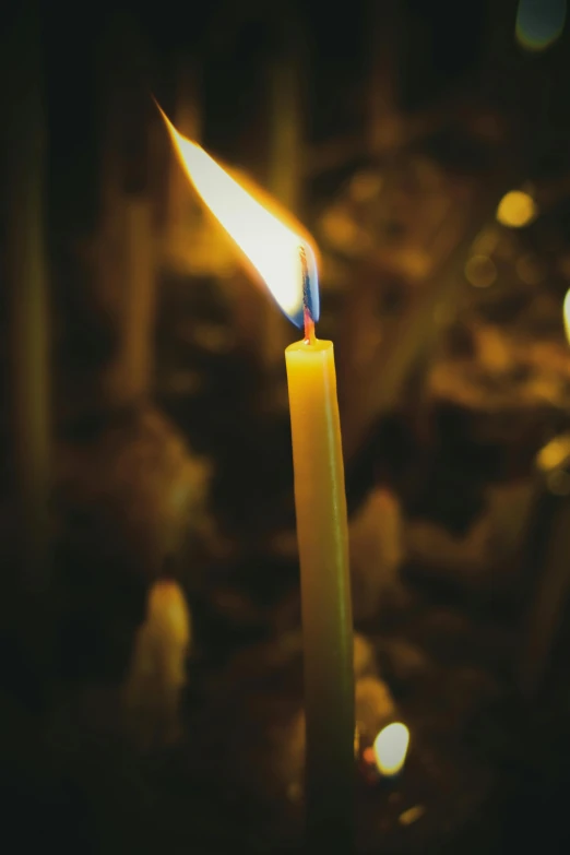 a candle is lit with its bright yellow flame