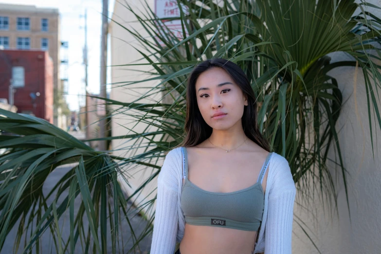 a girl stands in front of a potted plant