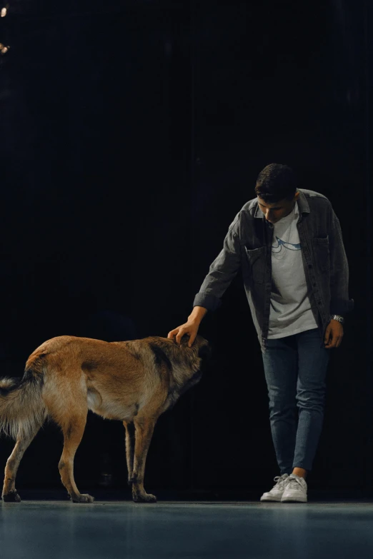a man petting a dog standing on top of a runway