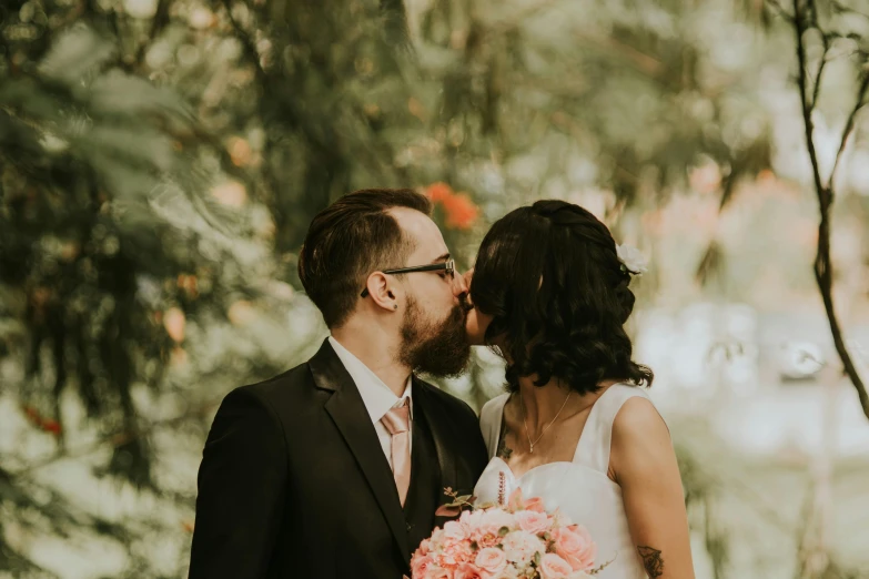 bride and groom kissing in a forest