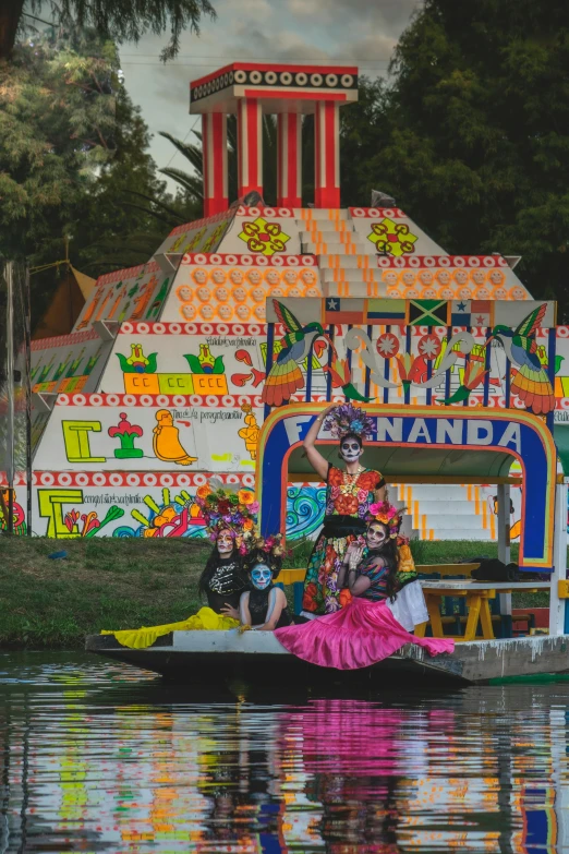 some people wearing colorful costumes on top of a boat