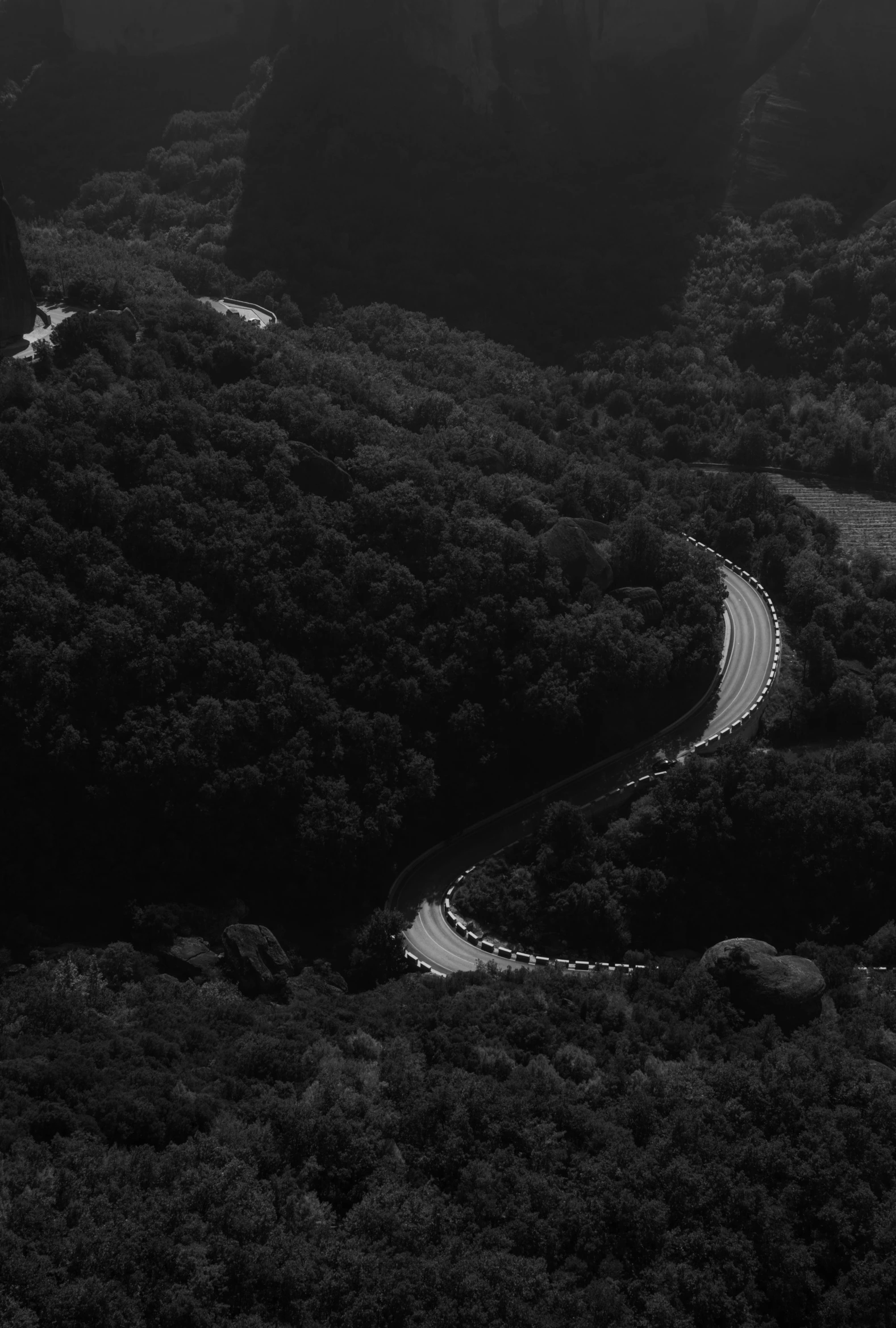 a view looking down on a mountainous road and mountains