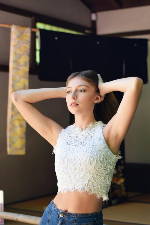 the girl is posing in jeans and an open shirt