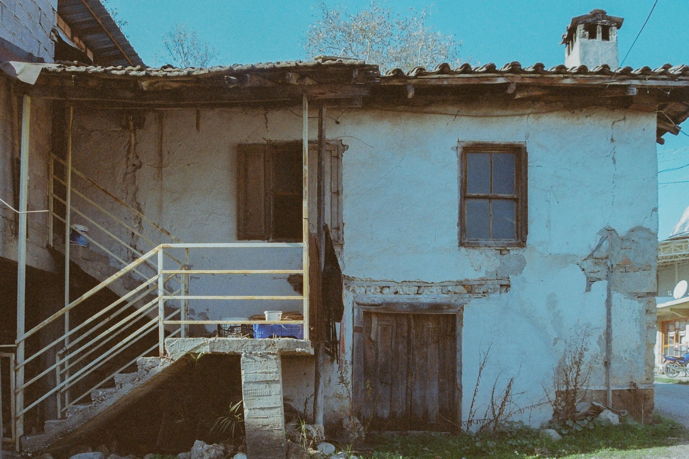 an old white house has a small balcony