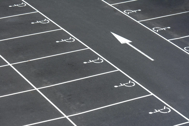 a white arrow points towards the center of an empty parking lot