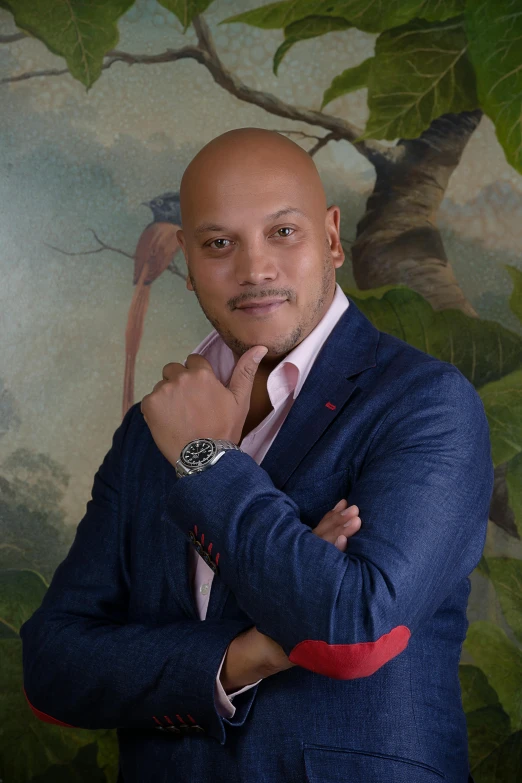 a man in a suit stands near a tree