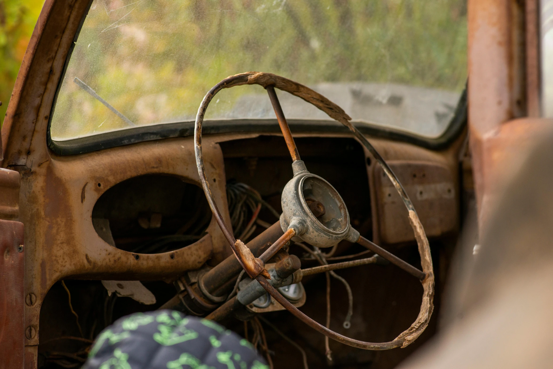 an old rusted out car with steering and dash wires