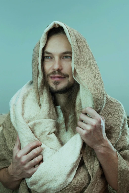 a man wrapped in a robe smiling while standing