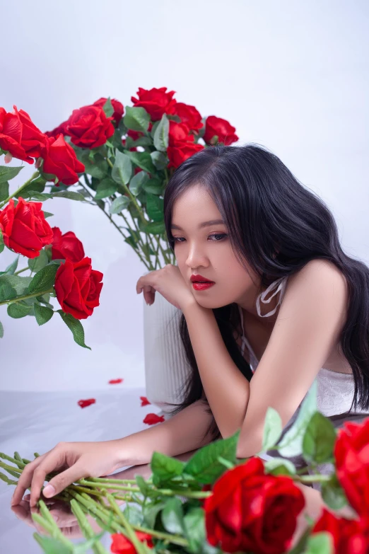 young asian woman with flowers in foreground looking at camera