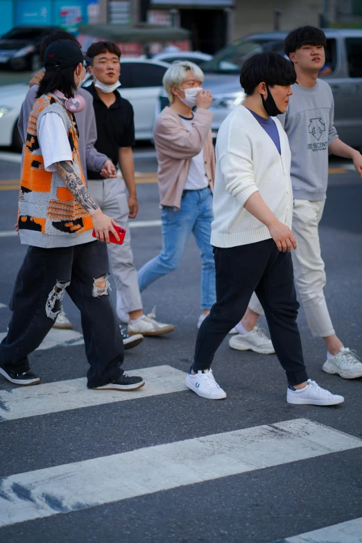 several people are walking across a crosswalk