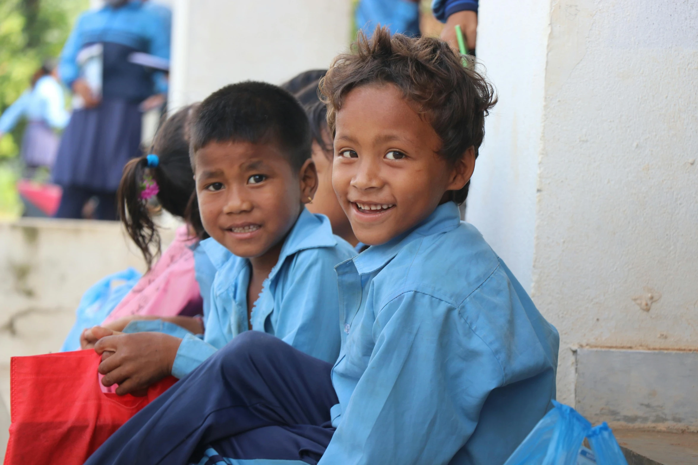 two children sitting on the floor and one of them is smiling