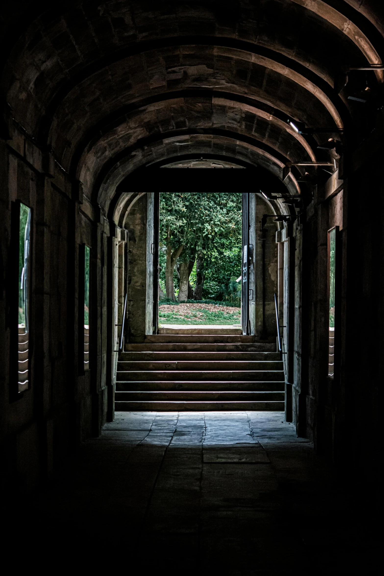 there is an arched passageway leading into the woods