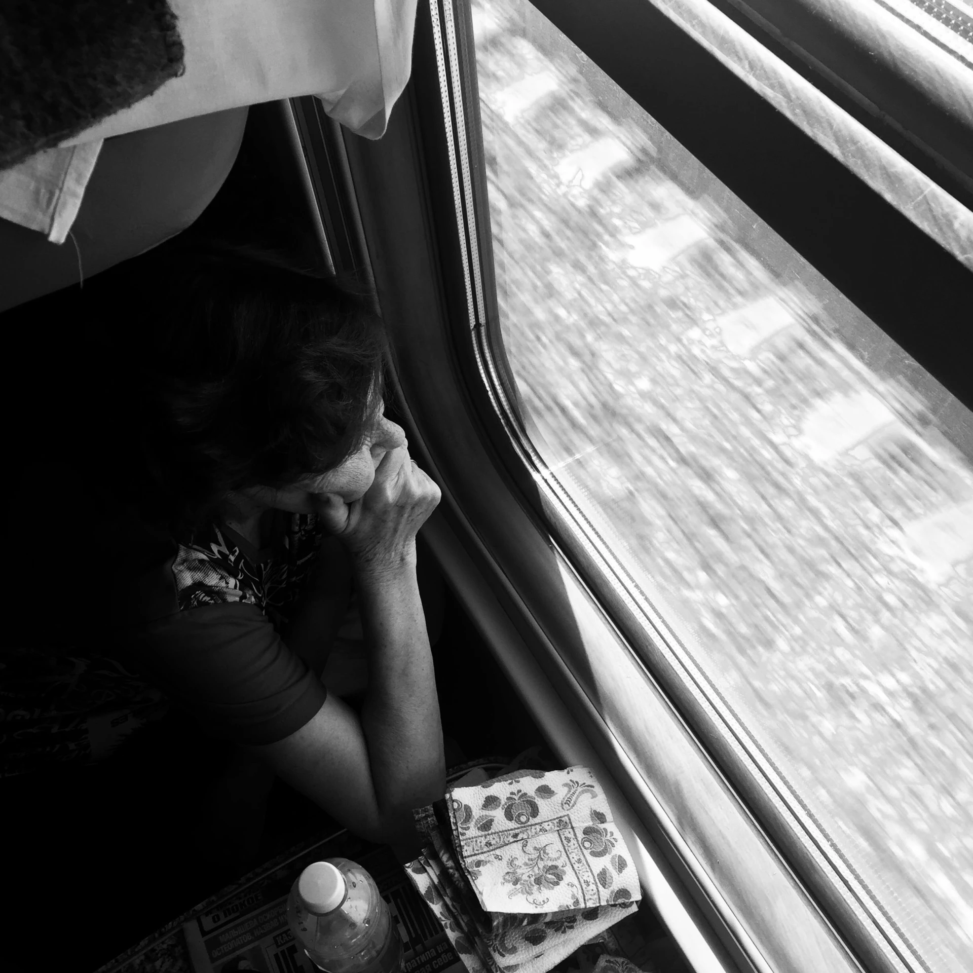 a person sitting down on a train looking at their cell phone