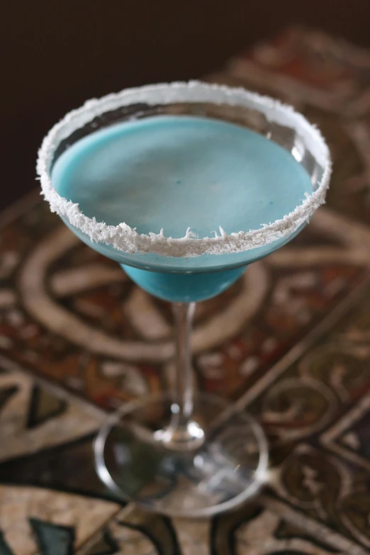 a margarita cocktail is in a goblet with ice on top