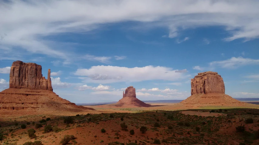 an old west desert scene, showing large mountain formations and rocks in the background