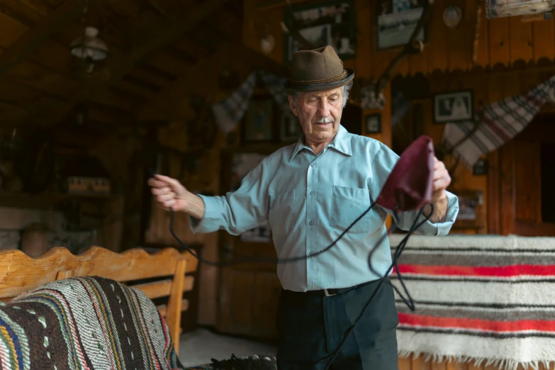 an older gentleman holds soing while standing by a couch