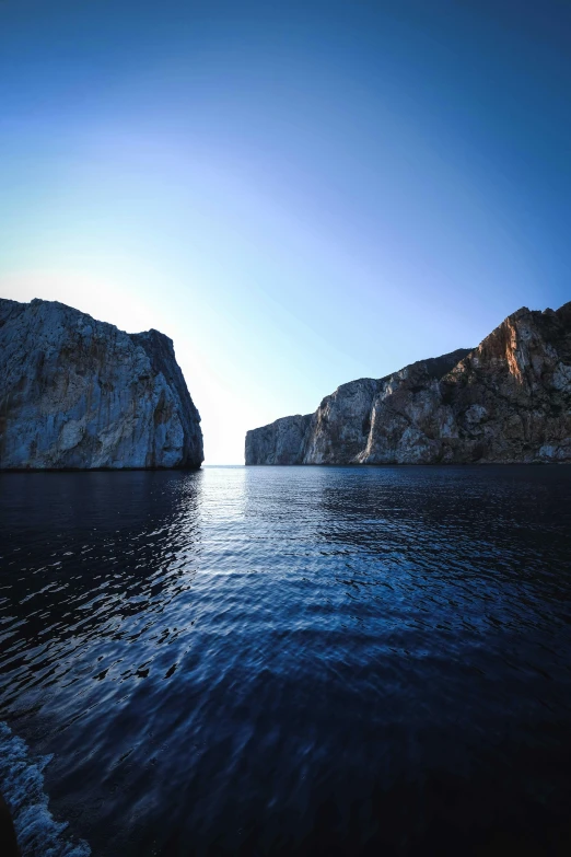 the water with large rocks at the edge is blue