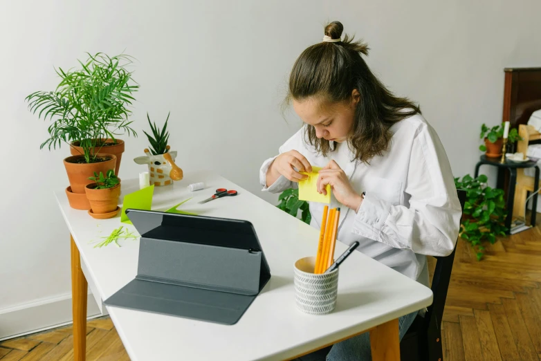 a woman sitting at a table working on a project