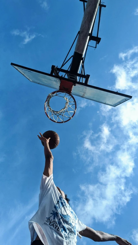 a basketball player dunks a ball over his head