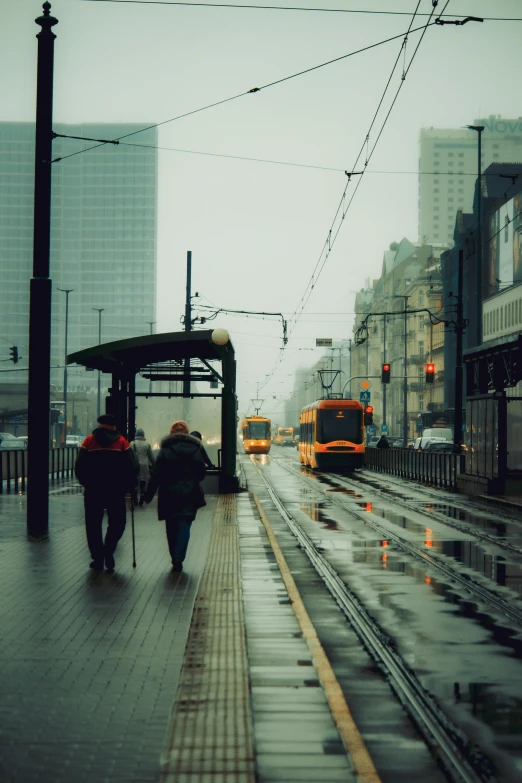 a bus and three people are walking along a train track