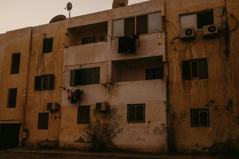 a very old building with broken windows and some plants