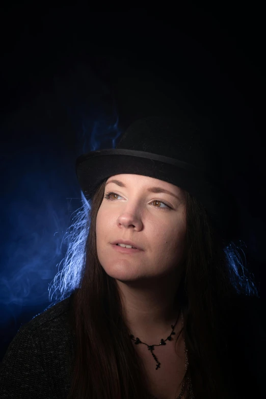 a woman wearing a hat with a dark blue background