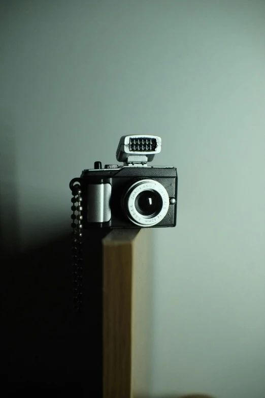 a camera is on a wooden beam near a wall