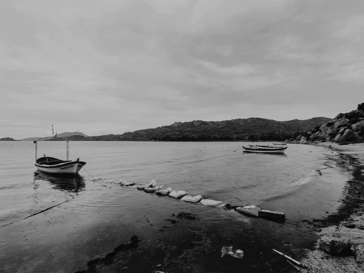 a boat is parked on the beach, next to a rock ledge