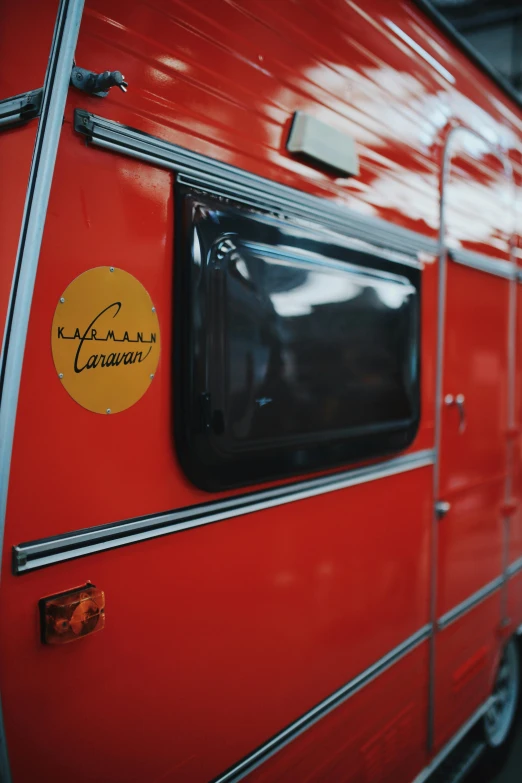 a red camper with the name of the camper written on the window