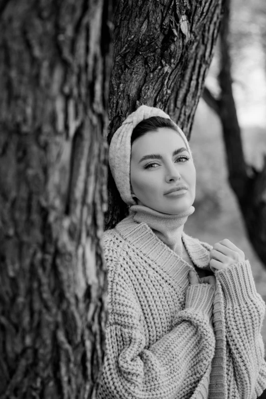 a woman standing by the side of a tree