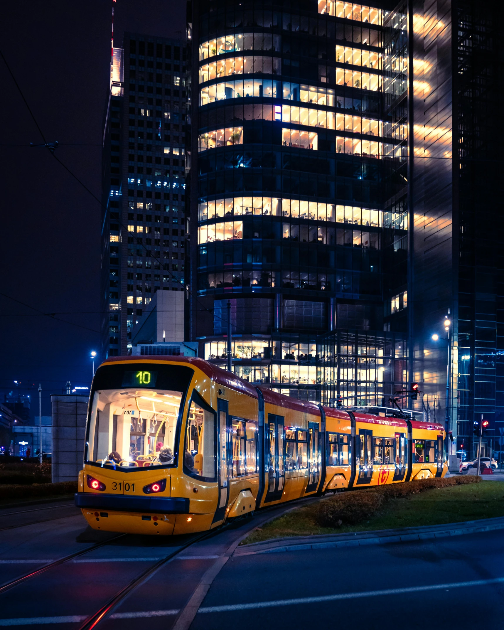 several buses are driving down the street at night