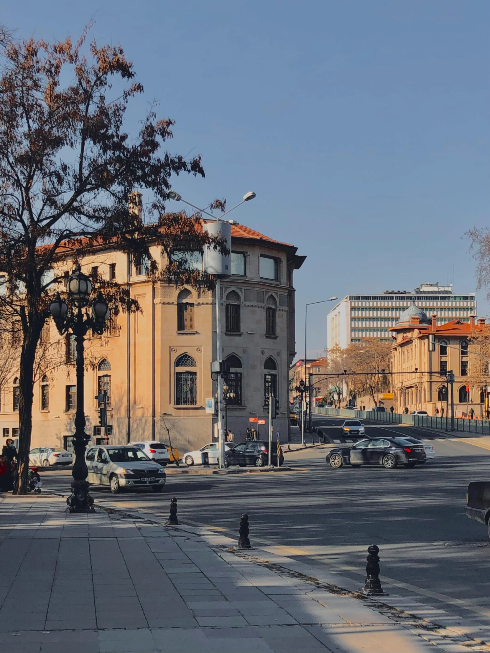 the view of an intersection in the town with cars on the street