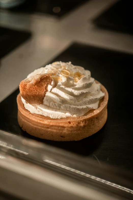 a pastry with white toppings sits on a black countertop