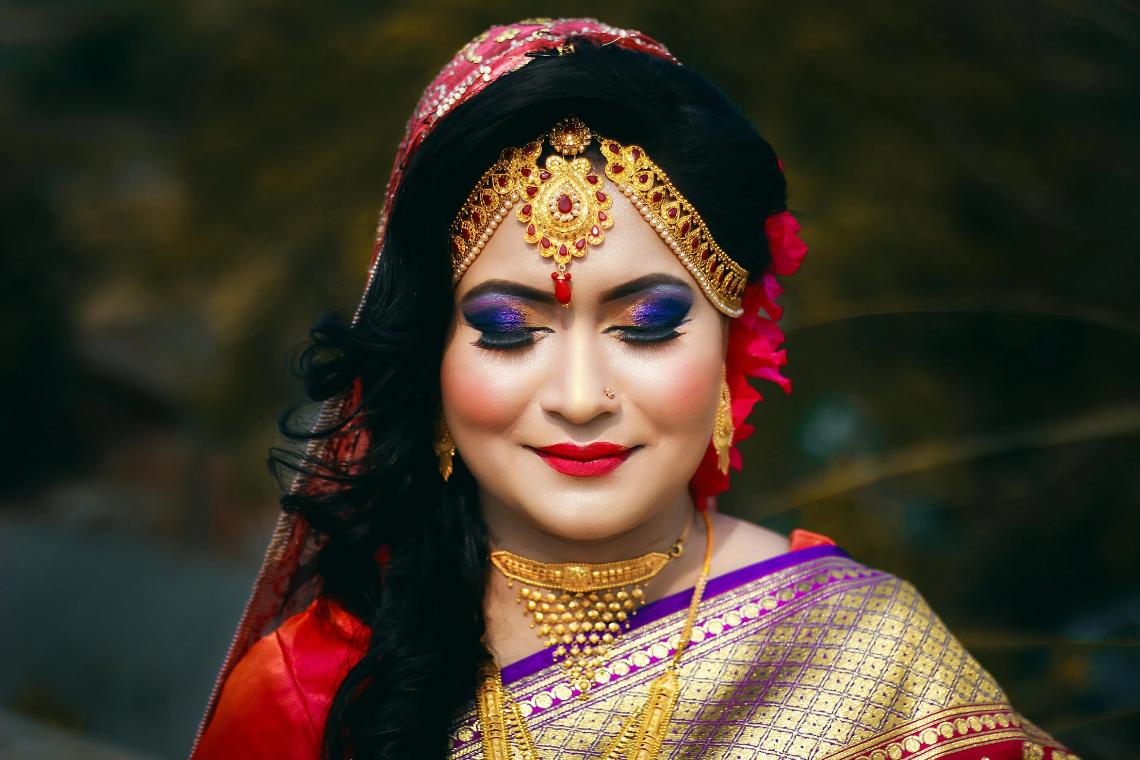 a woman with makeup in her eyes and traditional indian dress