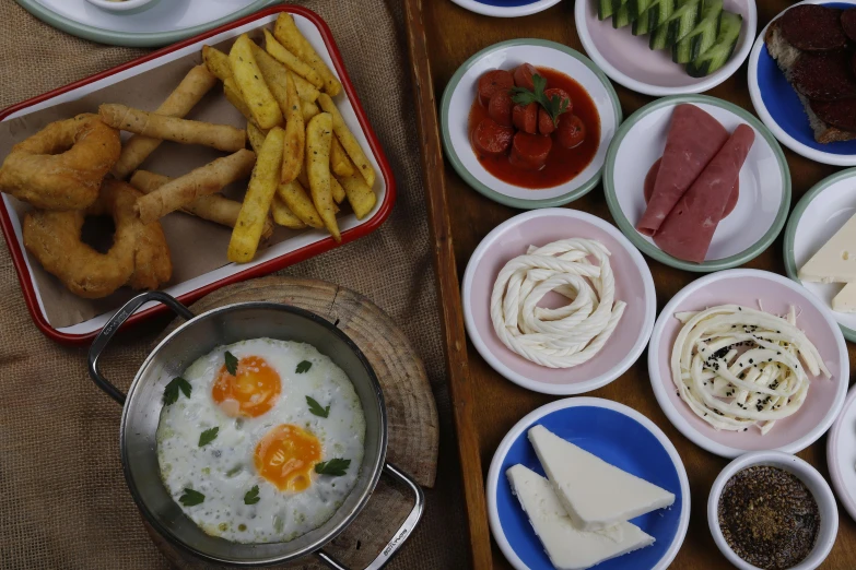 a table with a tray of food that includes cheeses, fruit and breadsticks