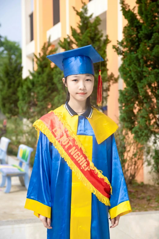 a young child in a blue graduation gown