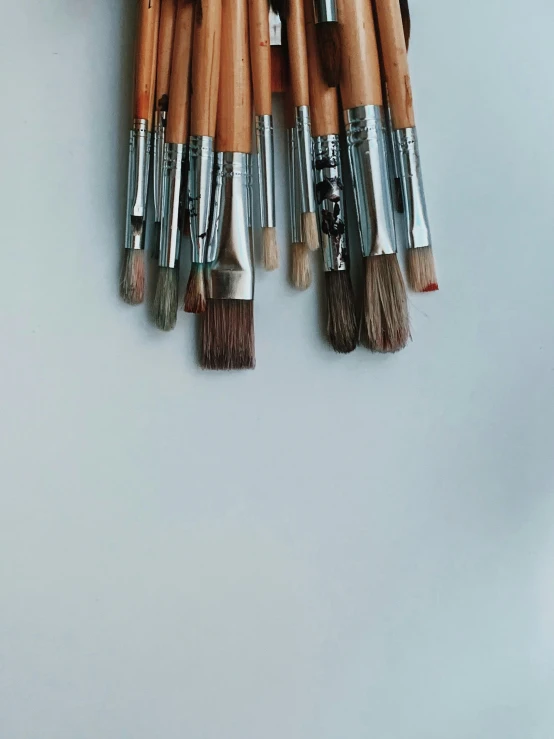 wooden and silver brushes are being held together