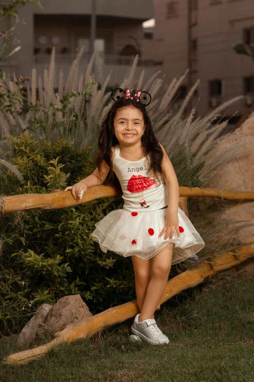 a little girl poses for the camera with her dress on