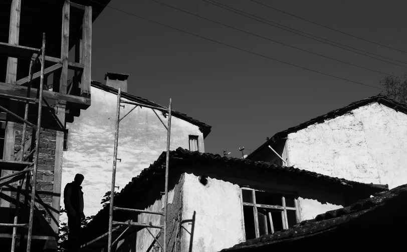 a man standing on top of a scaffold near some buildings