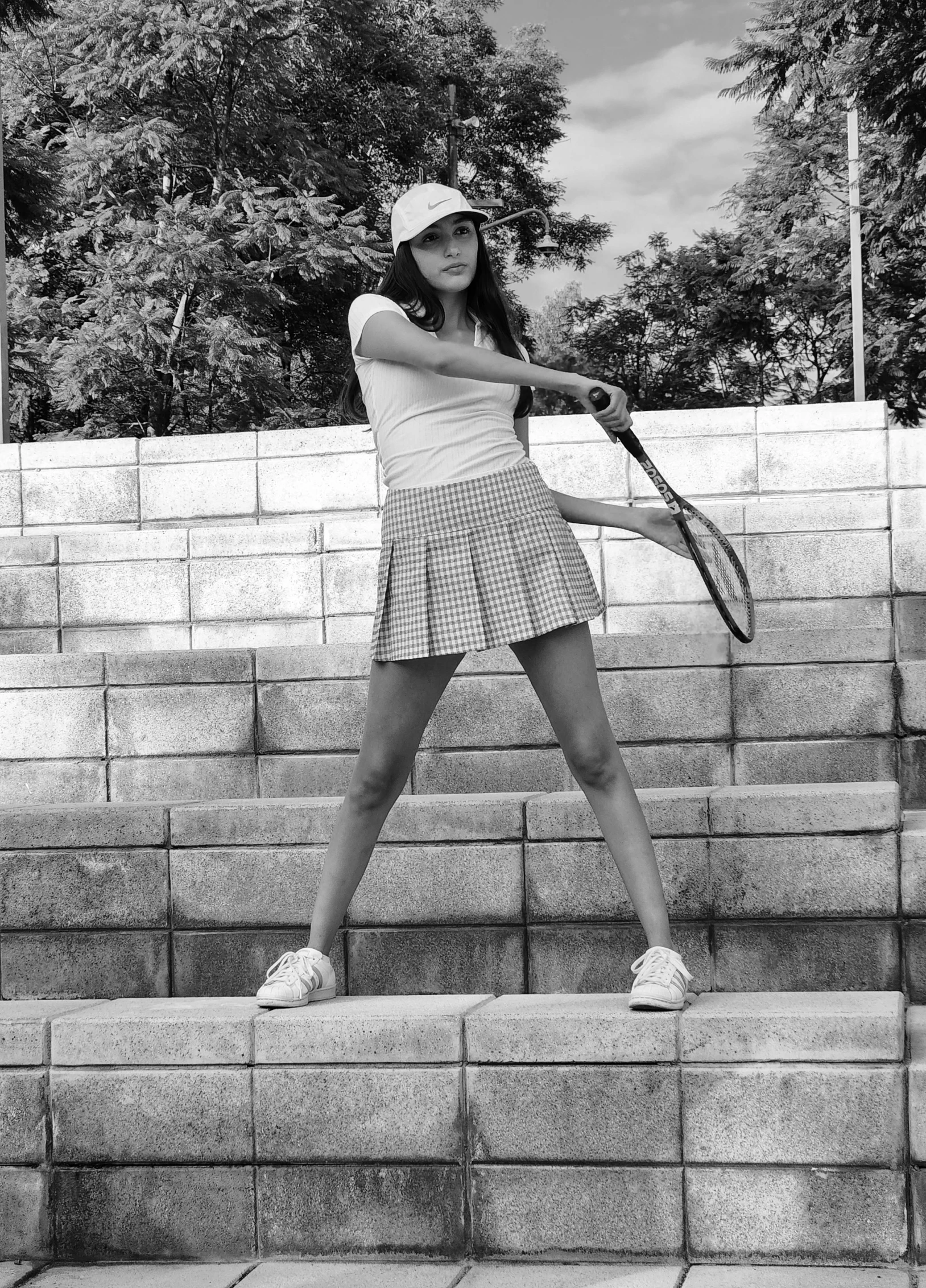 a woman is posed with her tennis racket