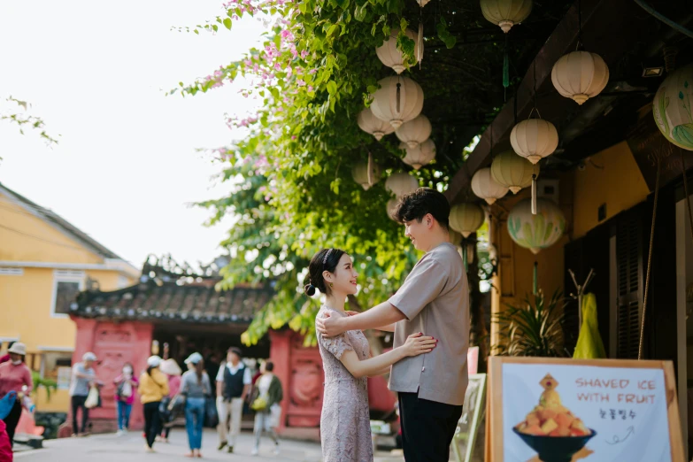 an asian couple performing dance in front of a food stand