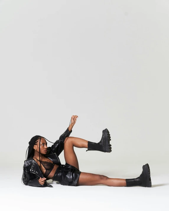 woman in high - rise leather outfit lying on the floor