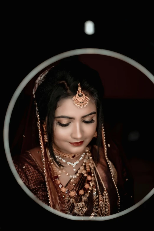 a beautiful woman in a golden outfit in a round mirror