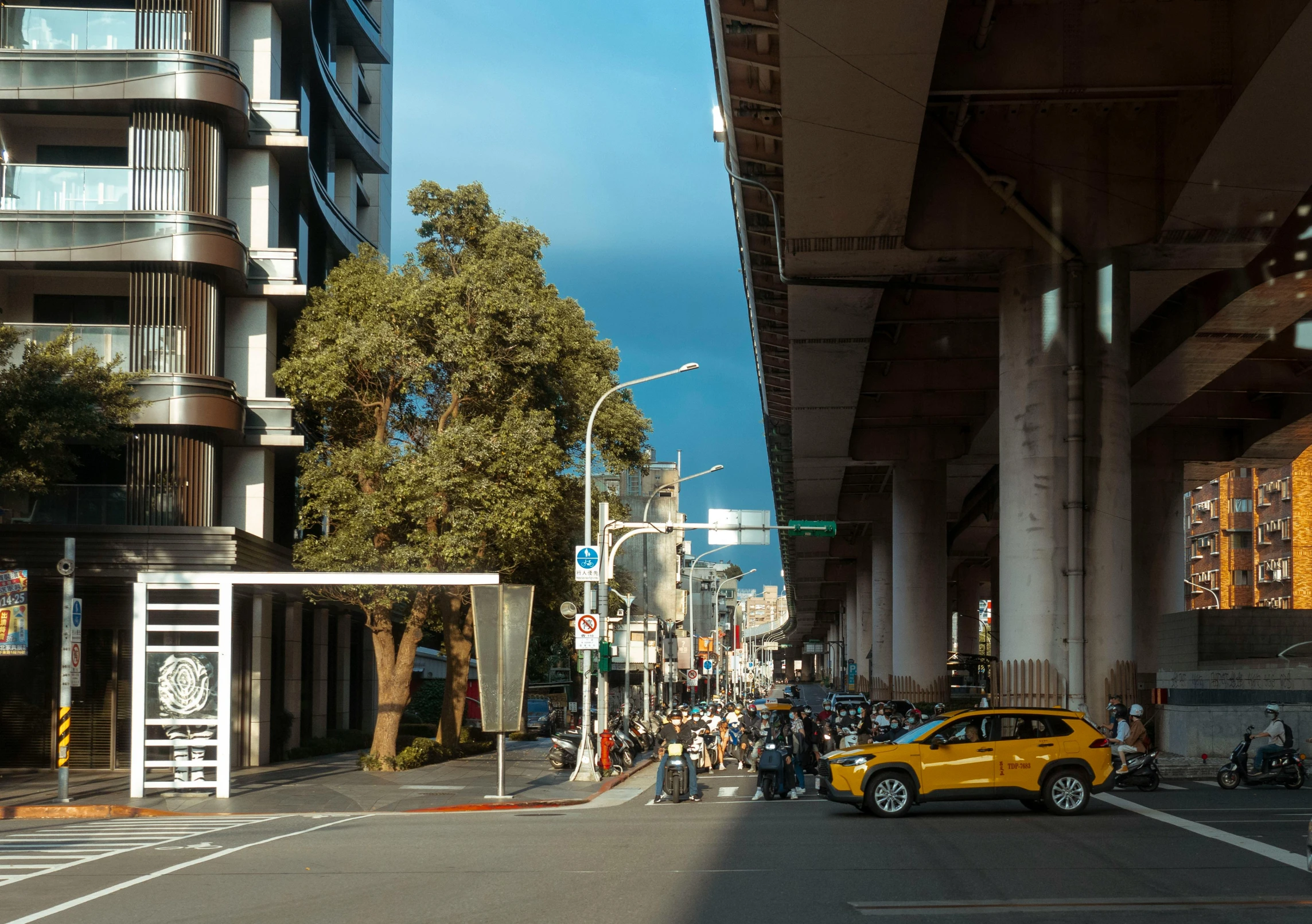 there is a yellow car that is driving down the street