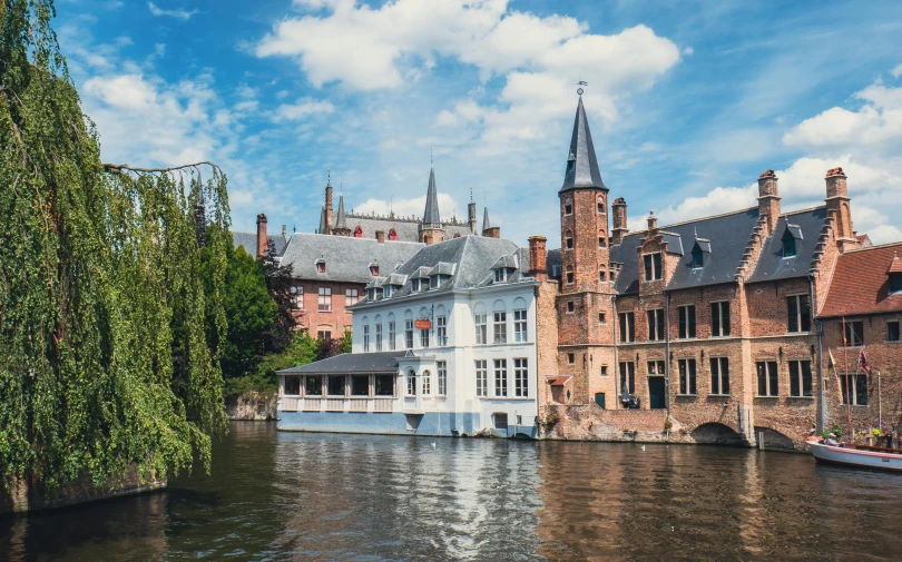 a row of buildings near the water with boats floating on the waters