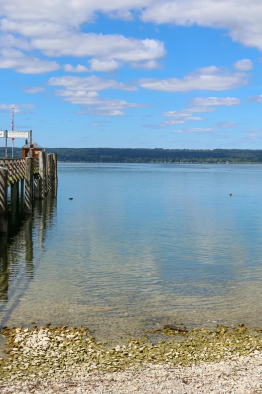 an old dock extending into a lake on a clear day