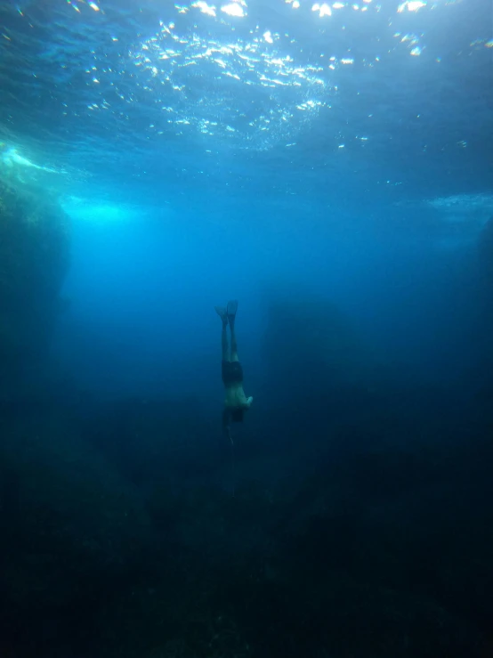 an underwater man standing in deep blue water