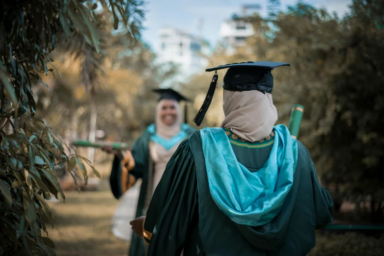 a graduate walks down the path with a guitar